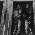 Handprints on a dark surface with a rustic wooden frame.