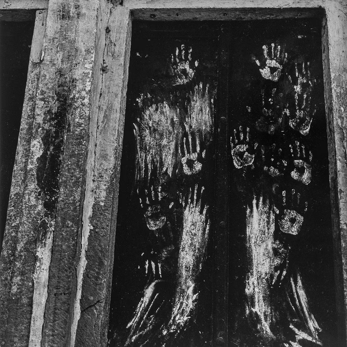 Handprints on a dark surface with a rustic wooden frame.