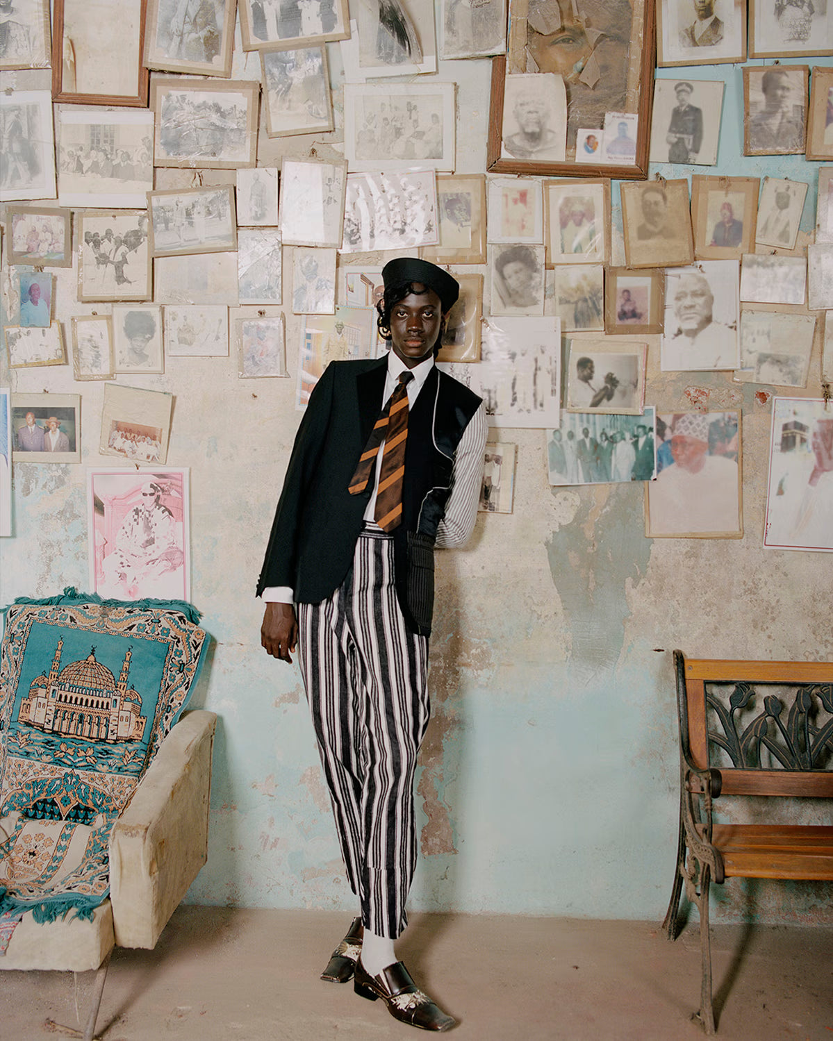 Person in formal attire standing in a room with vintage photos on the wall