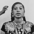Black and white portrait of a person wearing traditional jewelry and clothing.